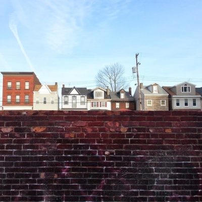 Bloomfield rowhouses seen over a wall