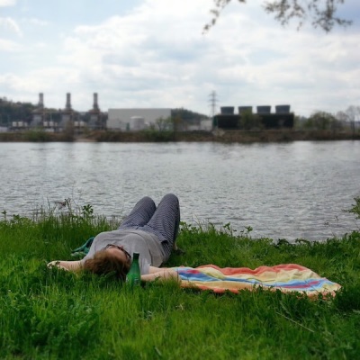 woman laying on grass by the Ohio River