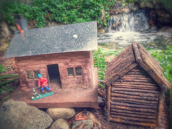 model log cabins with waterfall in background
