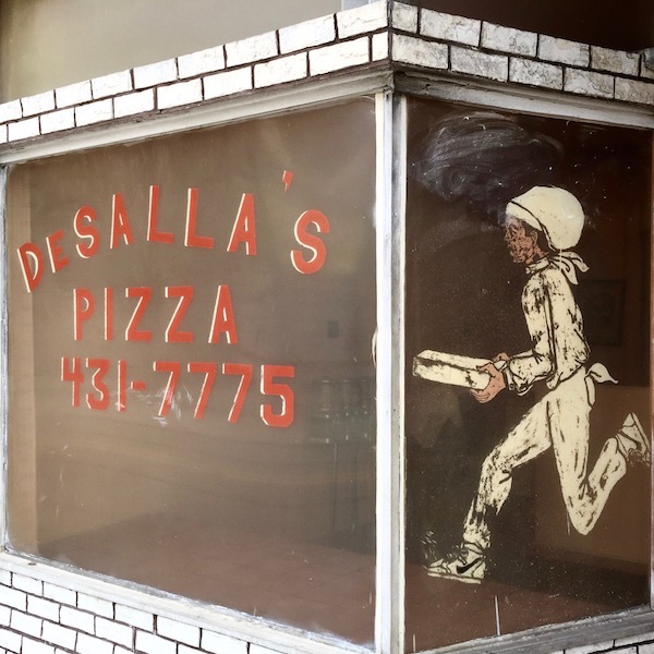glass storefront windows painted with the name of DeSalla's Pizza and running pizza delivery man, Pittsburgh, PA