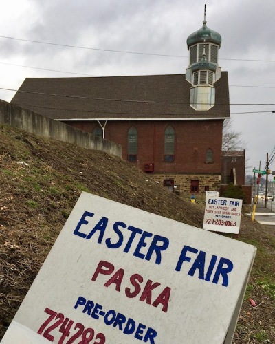 side view of St. Michael the Archangel Ukrainian Catholic Church with wooden signs for upcoming Easter fair, Lyndora, PA