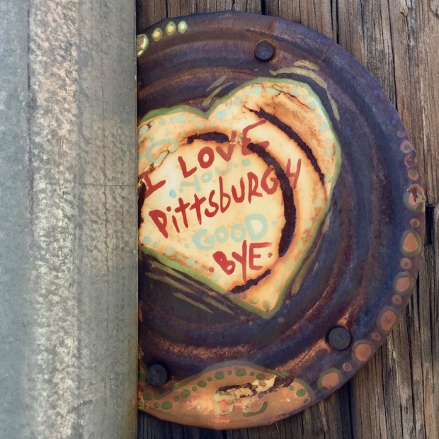 tin can lid painted with heart and text "I love you Pittsburgh. Goodbye." nailed to telephone pole. Pittsburgh, PA
