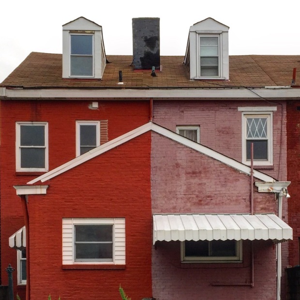 alley view of brick row houses painted red and pink, Pittsburgh, PA