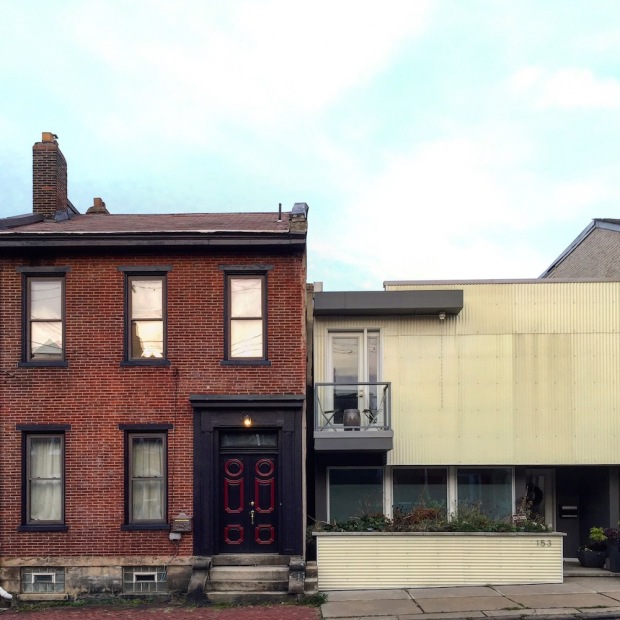 Victorian-era brick row house next to modern metal and glass row house, Pittsburgh, PA