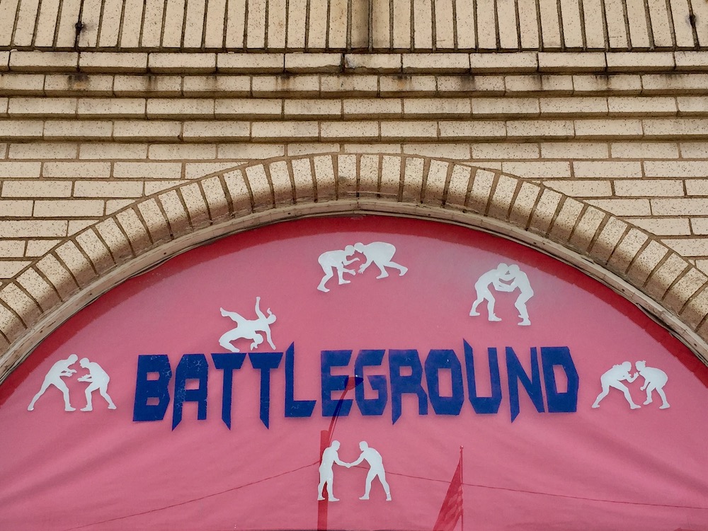 window signage for Battleground Training Center featuring silhouettes of two figures wrestling