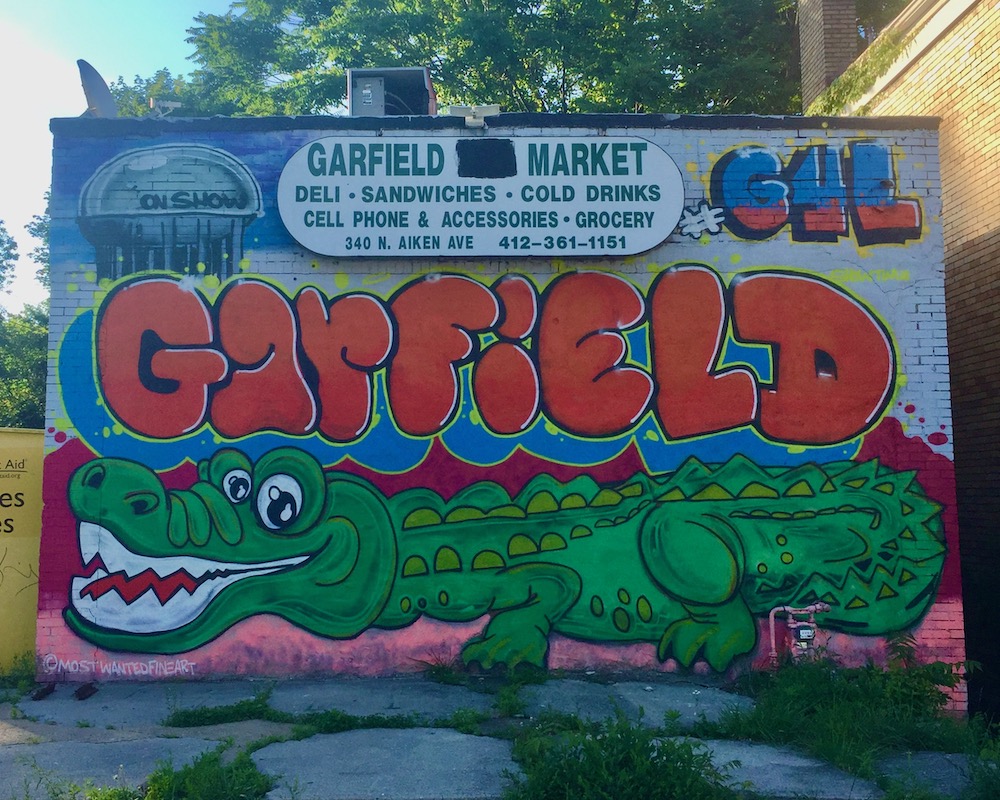 neighborhood welcome sign for Garfield, Pittsburgh painted on side of small market