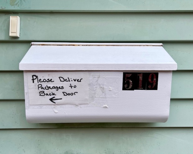 mailbox with hand-written instructions for package delivery