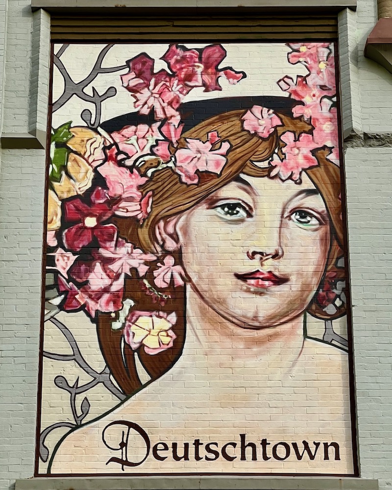 mural of woman with flowers in her hair for the Deutschtown neighborhood of Pittsburgh