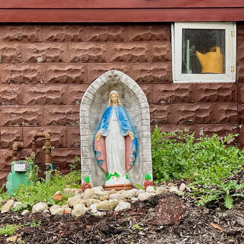 statue of Mary in front of older house