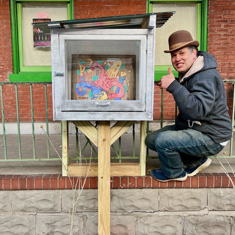 artist John Lee with a painting outside of Silver Apple Gallery, Pittsburgh