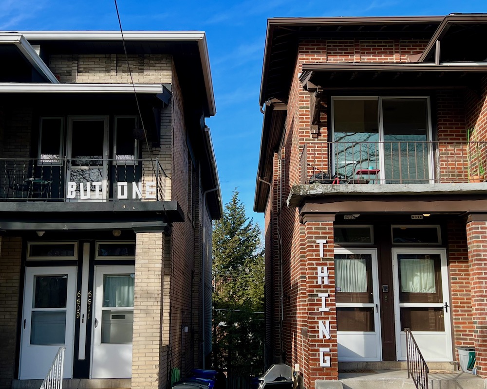 handmade letters attached to residential houses reading "but one thing"