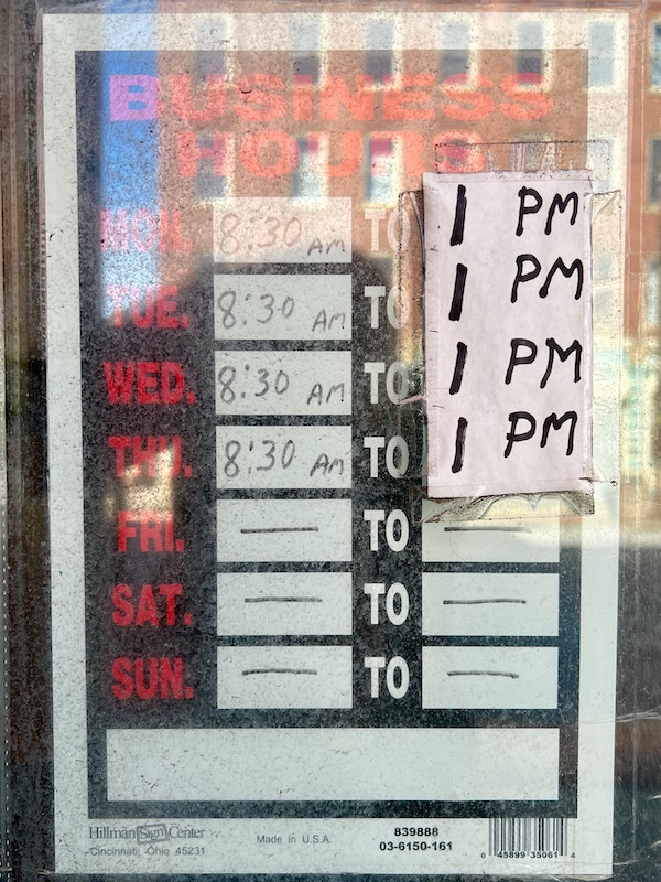 business hours with updates taped on glass