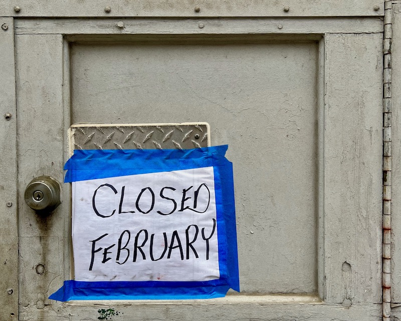 garage door with handmade "closed February" sign