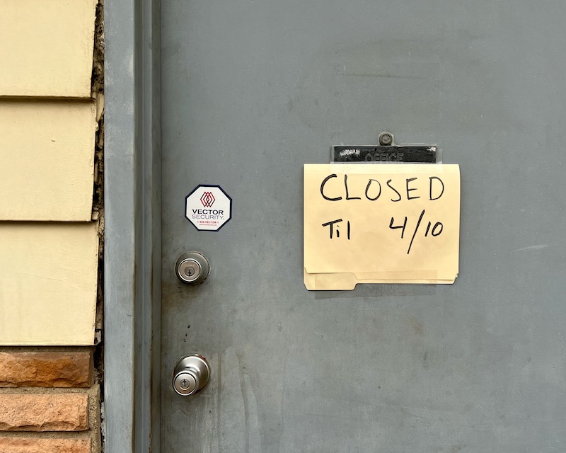 shop door with manilla folder labeled "Closed til 4/10"