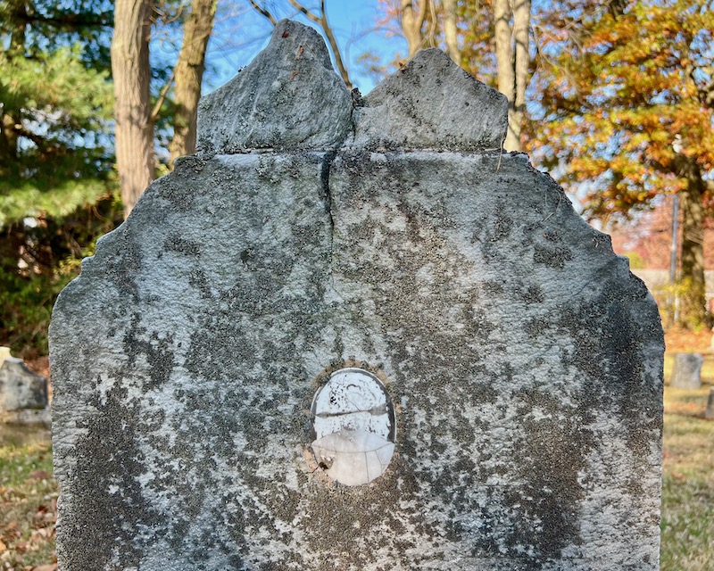weathered grave marker with inset ceramic photo