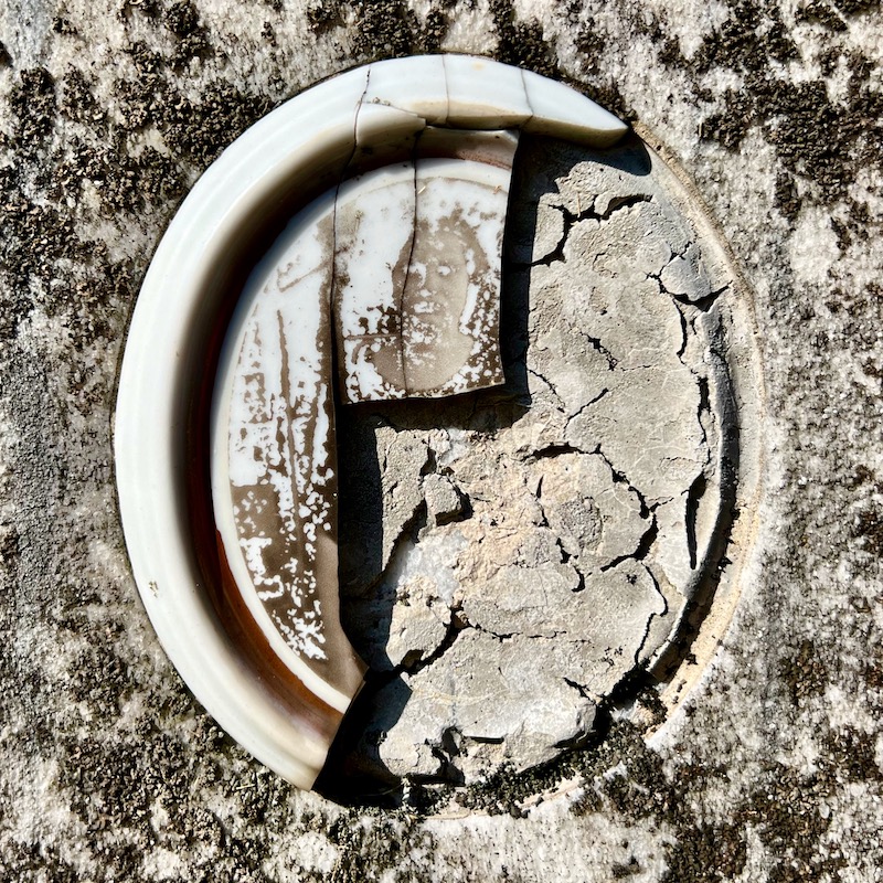 broken ceramic photograph inset in gravestone