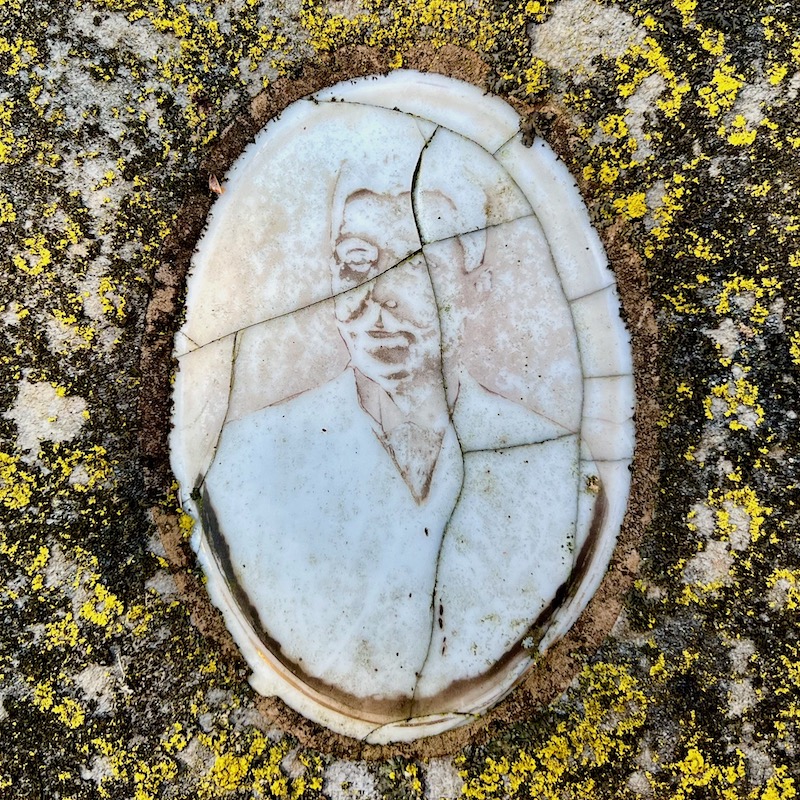 ceramic photo grave marker inset so faded as to appear ghost-like