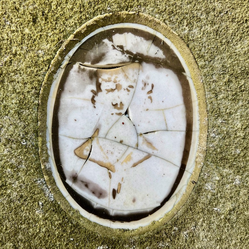 ceramic photo grave marker inset so faded it is unrecognizable as a person