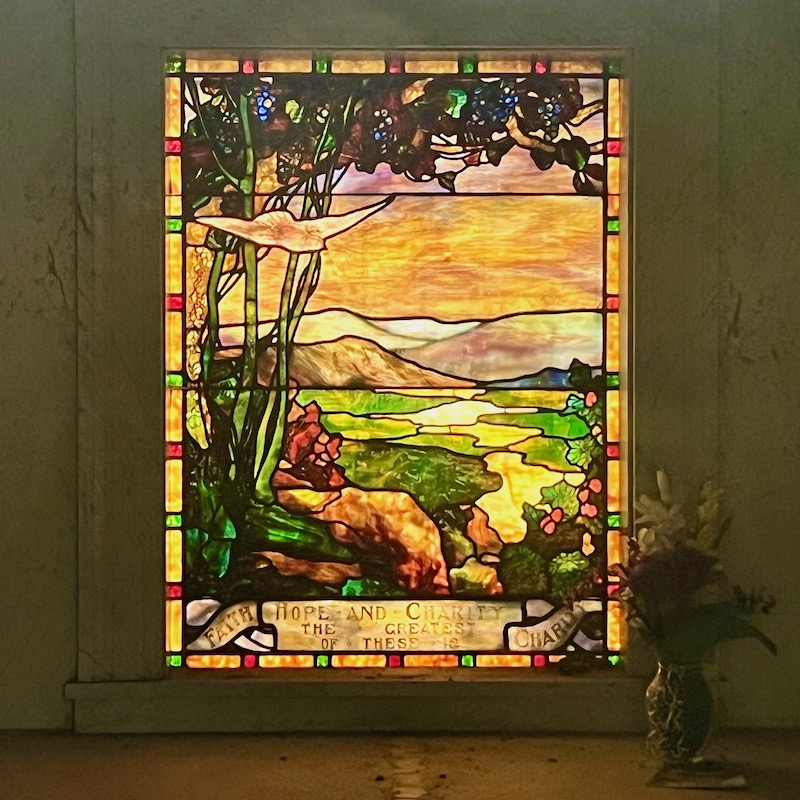 stained class window and vase in cemetery mausoleum