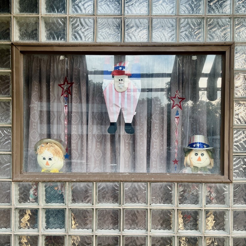 window inset into glass block wall with patriotic decorations