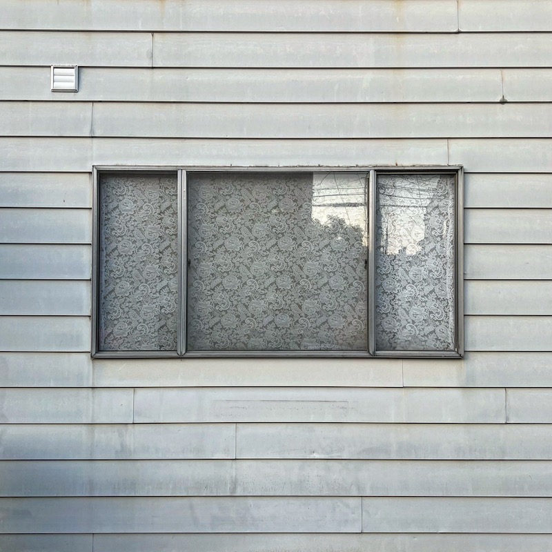 rowhouse window with lace curtain