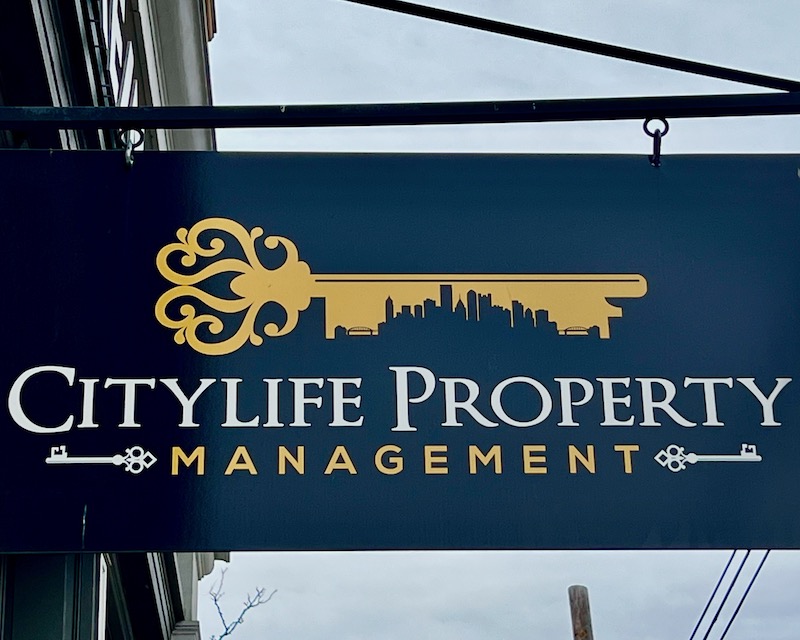 sign for property management company featuring skyline of downtown Pittsburgh