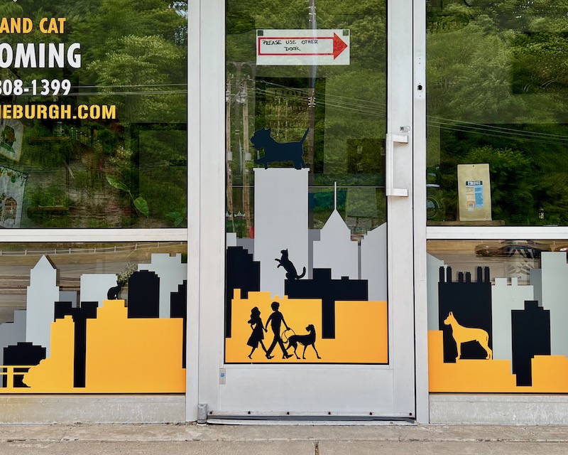 retail windows decorated with image of Pittsburgh skyline