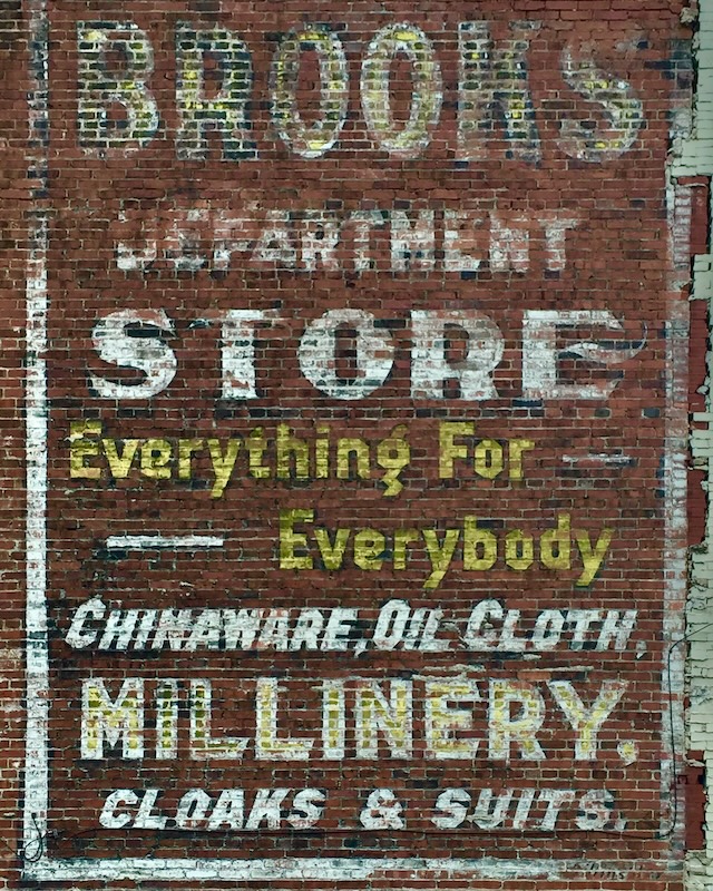hand-painted sign for department store painted on brick wall