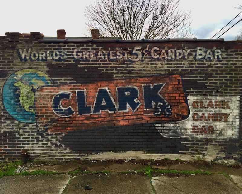 brick wall painted with faded advertisement for Clark candy bars