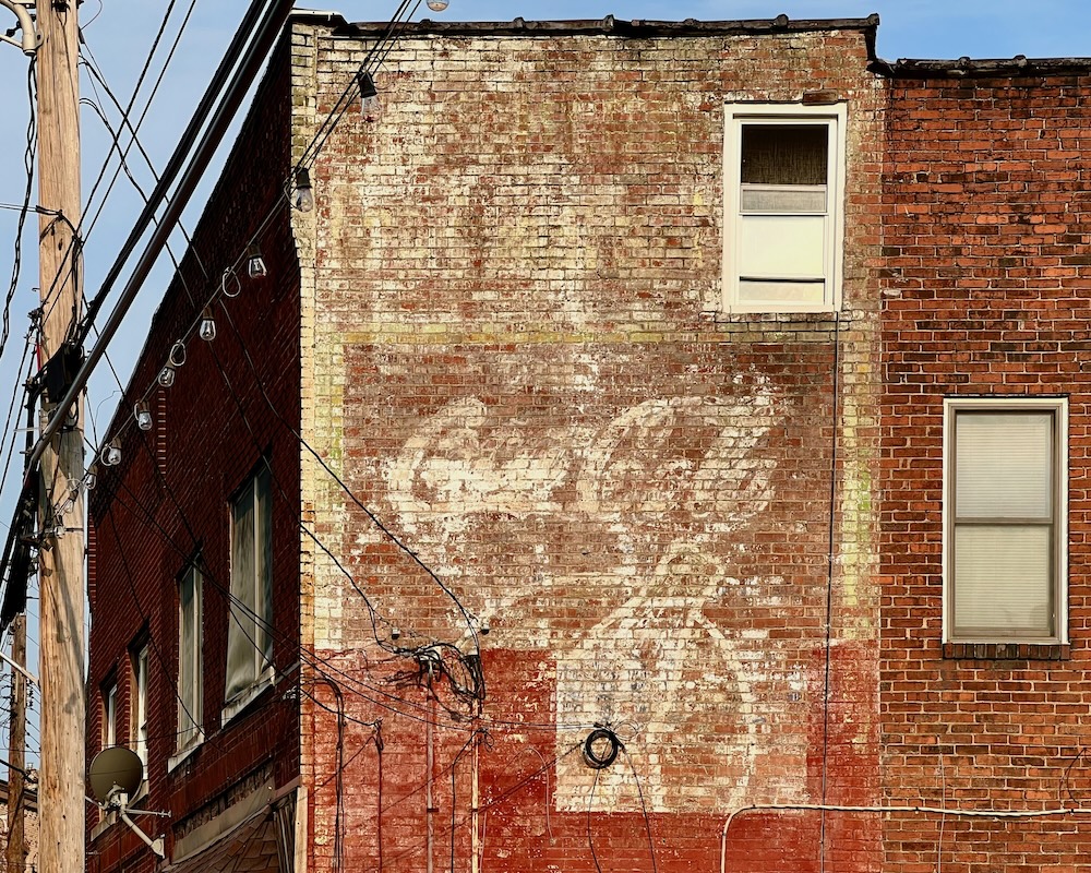 brick wall painted with faded advertisement for Coca-Cola