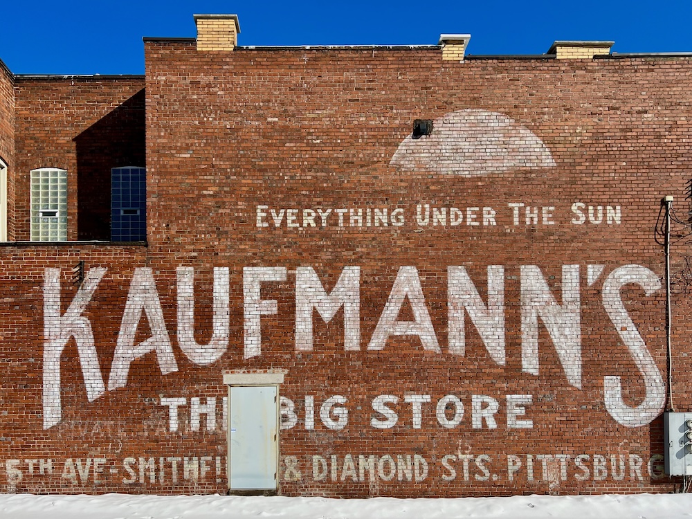 faded hand-painted sign for Kaufmann's Department Store painted on brick wall