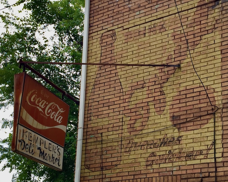 brick wall painted with faded advertisement for Squirt soda-pop